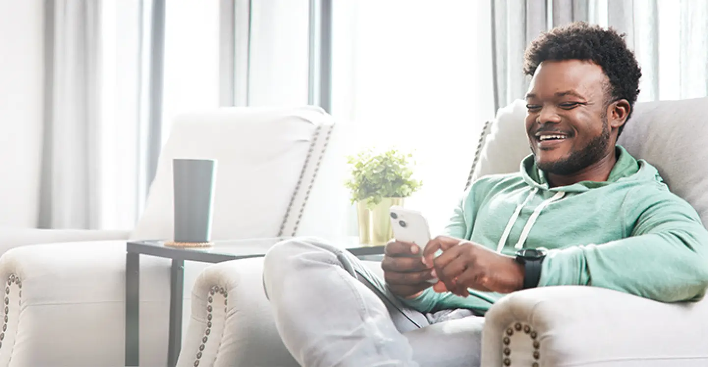 Chris, a real person with narcolepsy with cataplexy taking WAKIX, sitting with his phone